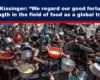 Expose News Crowd gathers with pots for food distribution amid global trust talk, highlighting urgency and hope in challenging times.